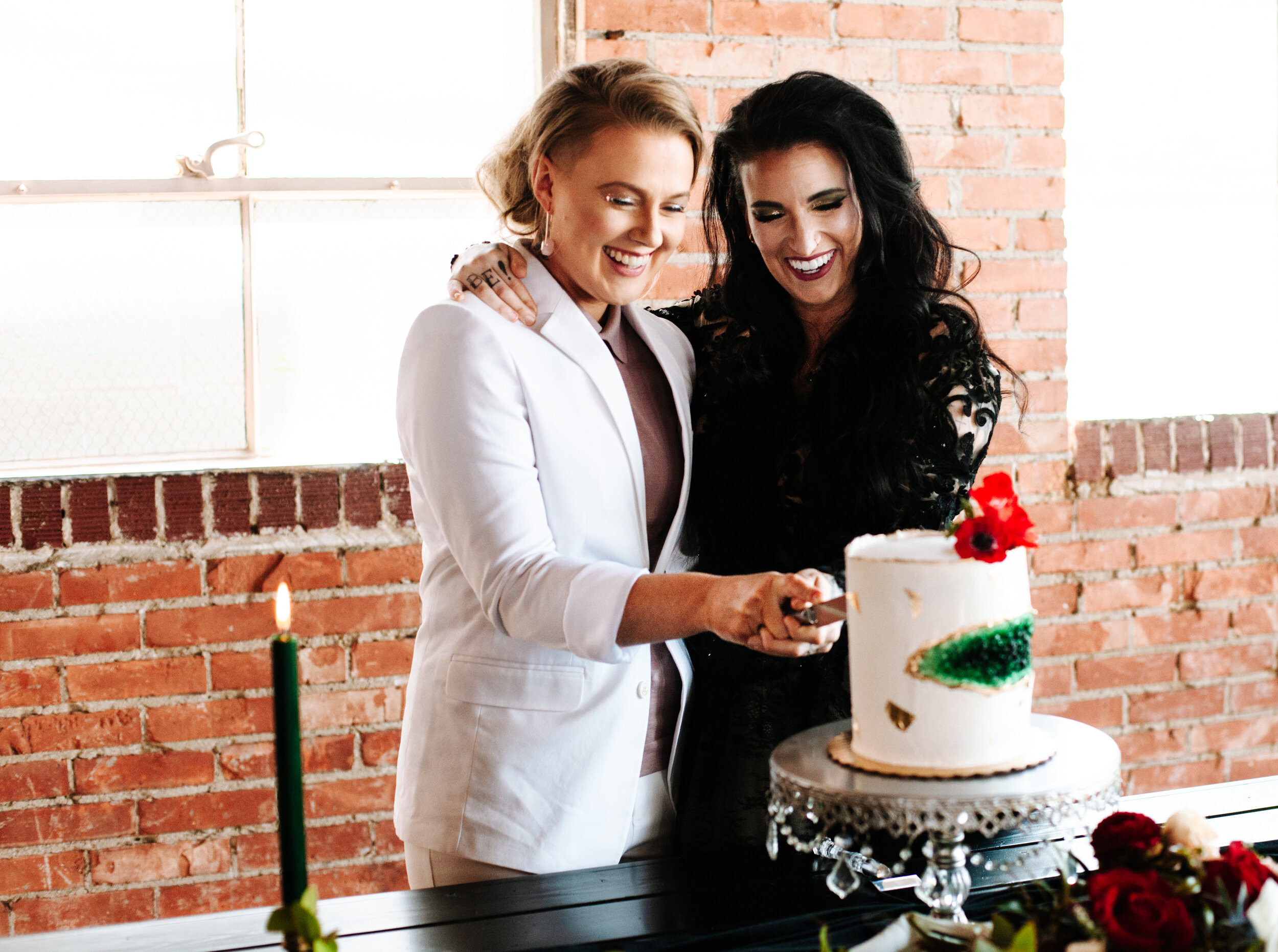 Lesbian couple cutting their wedding cake provided by Something Frosted bakery in Utah. 