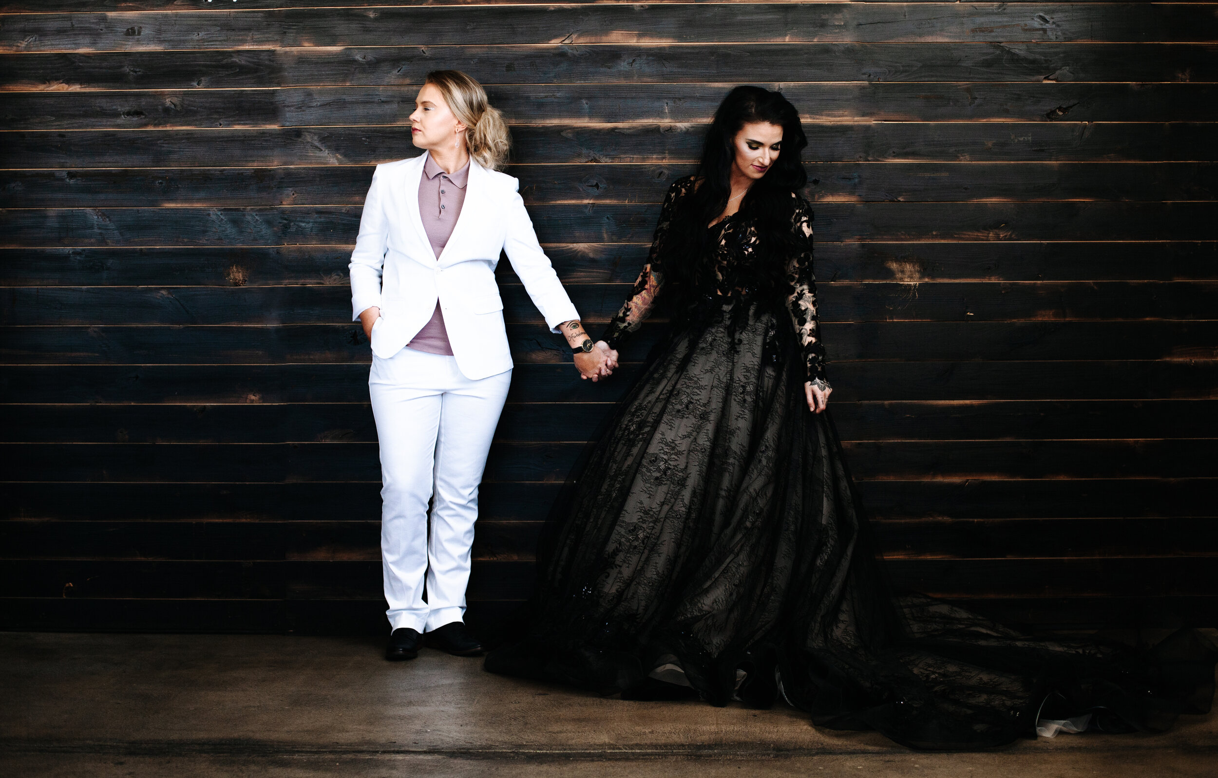 Lesbian couple standing together holding hands at their wedding in Utah. 