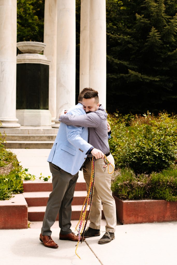 LGBTQ+ couple hugging at their wedding near the Utah State Capitol.