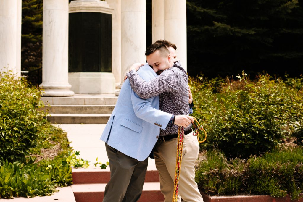 LGBTQ+ couple hugging at their wedding near the Utah State Capitol.