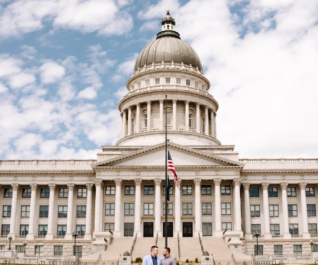 LGBTQ+ couple at their wedding in front of the Utah State Capitol.