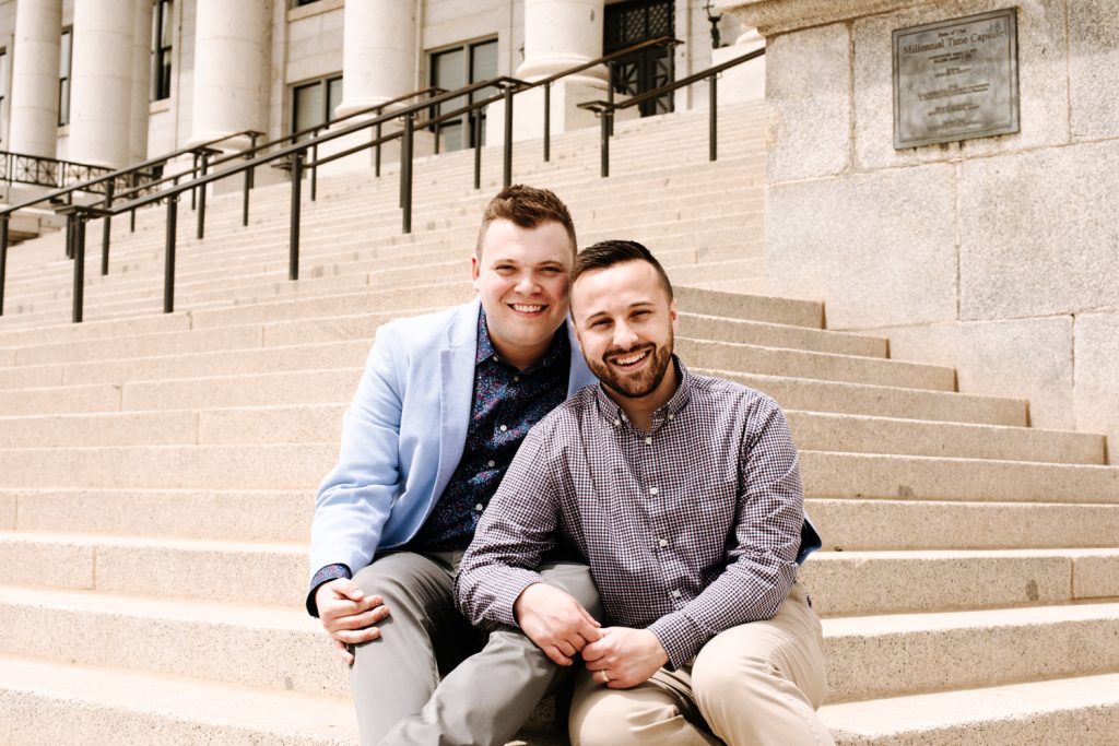 LGBTQ+ couple at their wedding on the stairs of the Utah State Capitol.