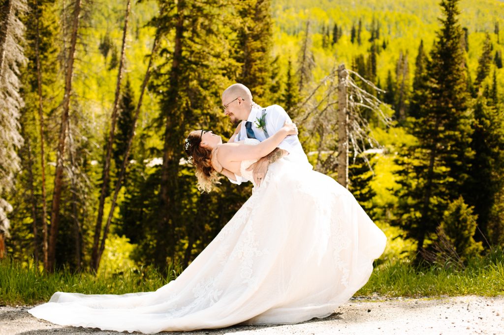 Groom dips bride at their wedding in the mountain of Park City at Solitude Mountain Resort